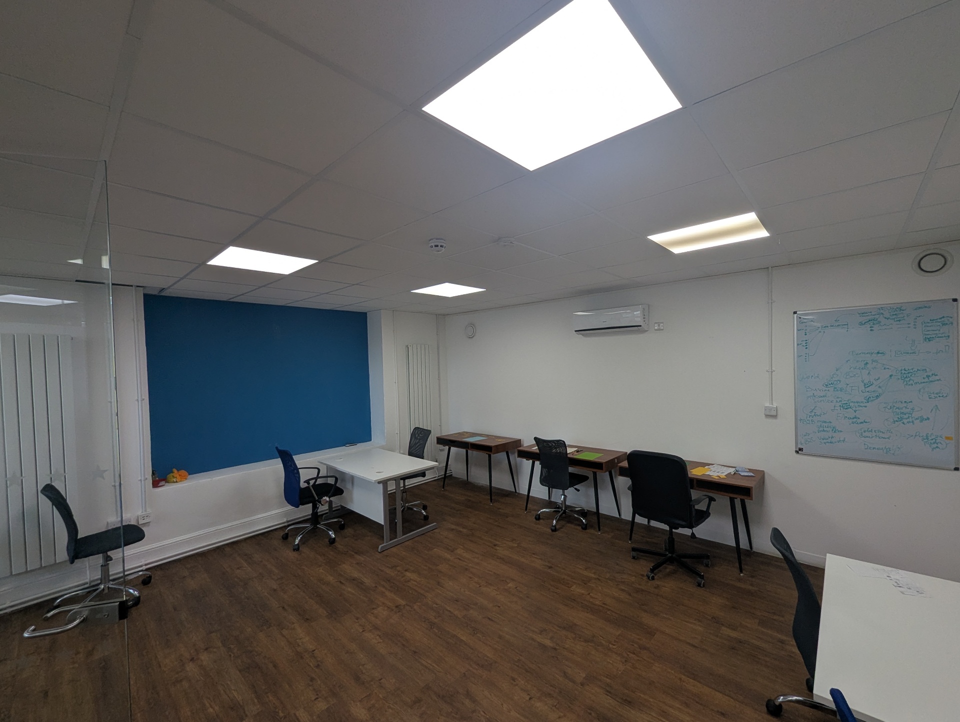 Room with blue accent wall and desks